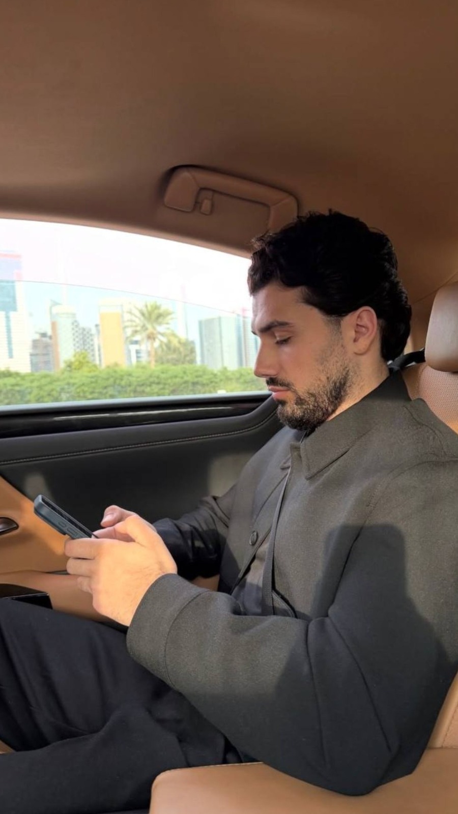 Hamza Kerem Kaya araç içinde telefonuna bakarken